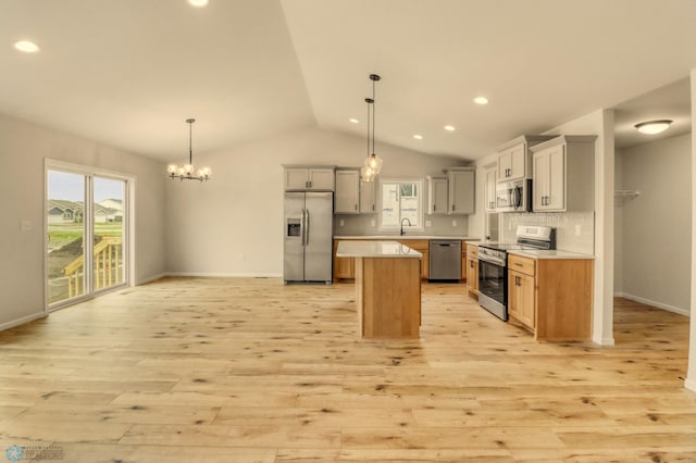1474 66th Ave S, Fargo, ND 58104 - kitchen with stainless steel appliances, light wood finished floors, lofted ceiling, a kitchen island, and light countertops