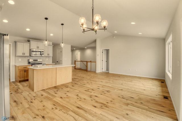 1474 66th Ave S, Fargo, ND 58104 - kitchen with appliances with stainless steel finishes, vaulted ceiling, light wood-type flooring, recessed lighting, and backsplash