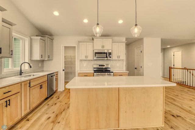1474 66th Ave S, Fargo, ND 58104 - kitchen with stainless steel appliances, a sink, recessed lighting, light wood-style flooring, and backsplash