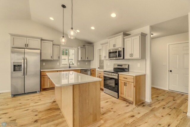 1474 66th Ave S, Fargo, ND 58104 - kitchen featuring appliances with stainless steel finishes, a sink, light countertops, vaulted ceiling, and backsplash