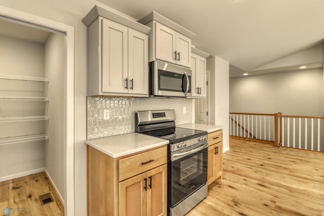 1474 66th Ave S, Fargo, ND 58104 - kitchen featuring stainless steel appliances, light wood finished floors, backsplash, light countertops, and baseboards