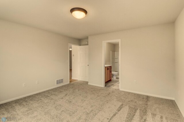 1474 66th Ave S, Fargo, ND 58104 - unfurnished bedroom featuring light colored carpet, baseboards, and connected bathroom