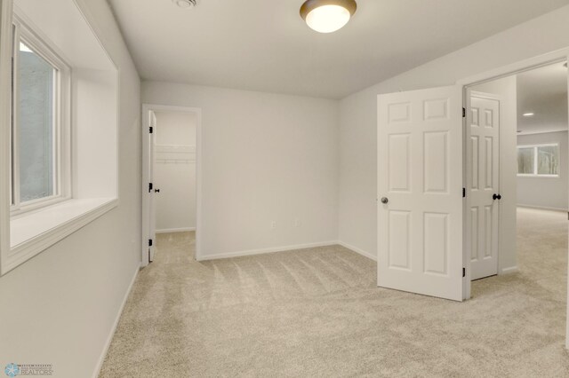 1474 66th Ave S, Fargo, ND 58104 - unfurnished bedroom with light carpet, a spacious closet, baseboards, and a closet