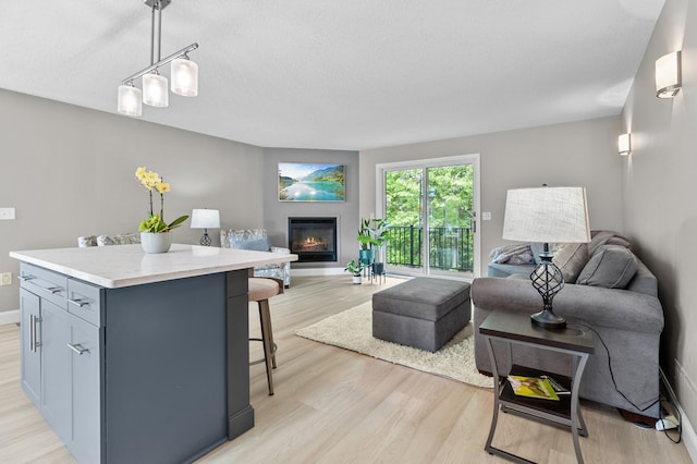 216 Crestview Cir, Jordan, MN 55352 - living room with light wood-style floors, a glass covered fireplace, baseboards, and a textured ceiling