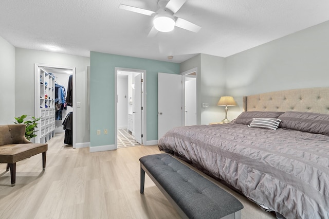 216 Crestview Cir, Jordan, MN 55352 - bedroom with light wood-type flooring, a walk in closet, ensuite bathroom, a closet, and baseboards