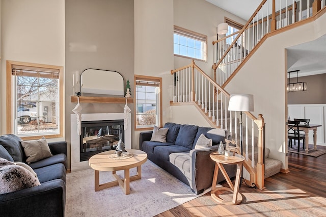 12828 43rd St NE, Saint Michael, MN 55376 - living room featuring a high ceiling, wood finished floors, stairs, a glass covered fireplace, and a chandelier