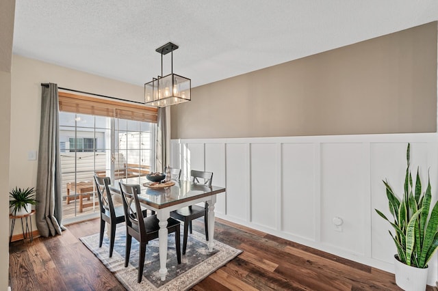 12828 43rd St NE, Saint Michael, MN 55376 - dining room featuring a decorative wall, a chandelier, dark wood-style flooring, wainscoting, and a textured ceiling