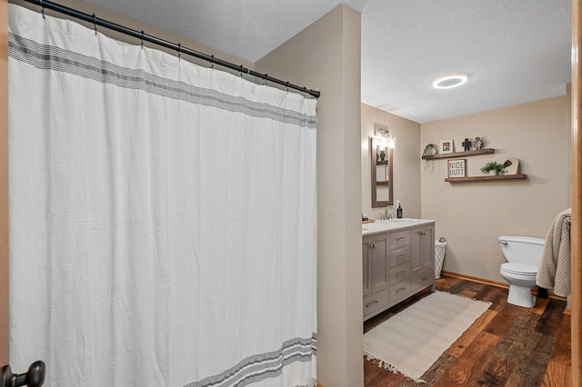 12828 43rd St NE, Saint Michael, MN 55376 - bathroom with toilet, wood finished floors, vanity, a textured ceiling, and baseboards