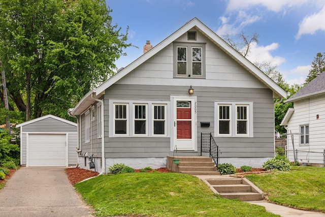 2005 Nokomis Ave, Saint Paul, MN 55119 - bungalow-style house with an outbuilding, a chimney, a detached garage, asphalt driveway, and a front lawn