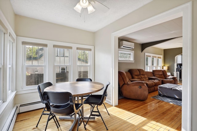 2005 Nokomis Ave, Saint Paul, MN 55119 - dining area with an AC wall unit, wood-type flooring, ceiling fan, a baseboard heating unit, and a textured ceiling