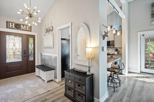 15657 Fish Point Rd SE, Prior Lake, MN 55372 - entryway featuring high vaulted ceiling, a chandelier, wood finished floors, and baseboards