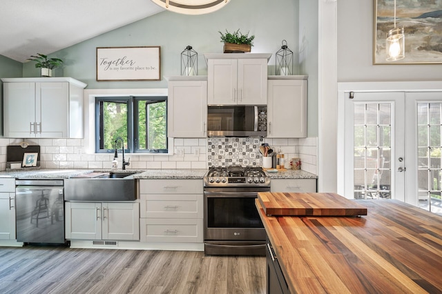 15657 Fish Point Rd SE, Prior Lake, MN 55372 - kitchen featuring butcher block countertops, appliances with stainless steel finishes, a sink, vaulted ceiling, and light wood-style flooring