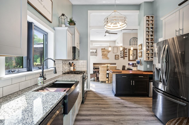 15657 Fish Point Rd SE, Prior Lake, MN 55372 - kitchen with appliances with stainless steel finishes, a ceiling fan, wood finished floors, backsplash, and wood counters