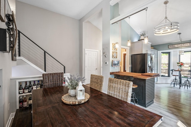 15657 Fish Point Rd SE, Prior Lake, MN 55372 - dining room featuring high vaulted ceiling, wood finished floors, baseboards, a chandelier, and stairs