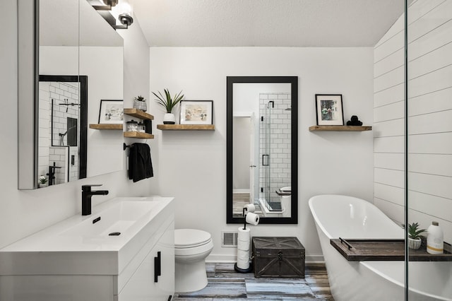 15657 Fish Point Rd SE, Prior Lake, MN 55372 - bathroom featuring a freestanding tub, vanity, a stall shower, wood finished floors, and a textured ceiling
