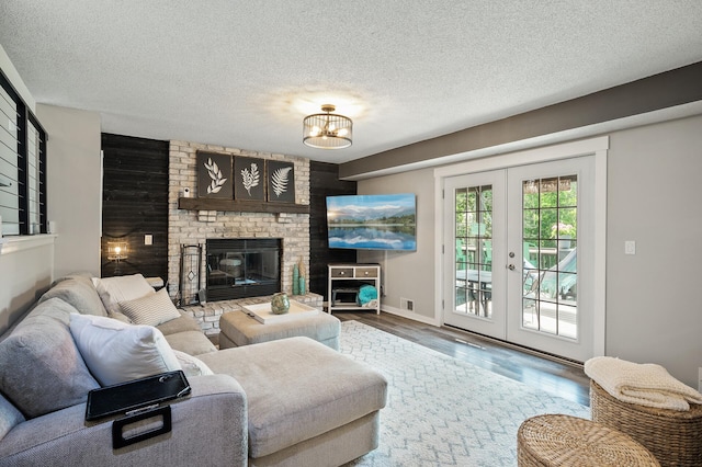 15657 Fish Point Rd SE, Prior Lake, MN 55372 - living area with french doors, wood finished floors, a textured ceiling, a chandelier, and a brick fireplace