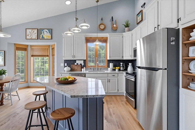 25809 Virgo St NE, Oxford Twp, MN 55079 - kitchen featuring appliances with stainless steel finishes, a sink, tasteful backsplash, white cabinets, and high vaulted ceiling