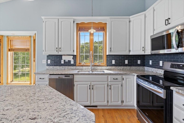 25809 Virgo St NE, Oxford Twp, MN 55079 - kitchen with stainless steel appliances, a sink, white cabinets, and plenty of natural light