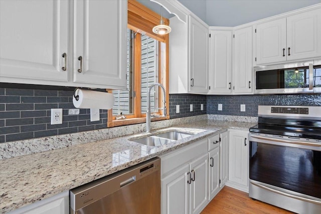 25809 Virgo St NE, Oxford Twp, MN 55079 - kitchen with appliances with stainless steel finishes, a sink, white cabinets, light stone counters, and backsplash
