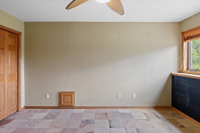 25809 Virgo St NE, Oxford Twp, MN 55079 - spare room featuring ceiling fan, baseboards, and light stone finish flooring