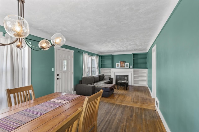 7537 Wentworth Ave, Richfield, MN 55423 - dining space featuring dark wood-style flooring, a fireplace, a textured ceiling, baseboards, and built in features