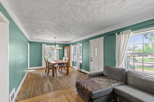 7537 Wentworth Ave, Richfield, MN 55423 - dining area with baseboards, a chandelier, hardwood / wood-style floors, and a textured ceiling