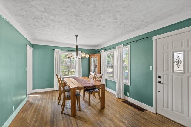 7537 Wentworth Ave, Richfield, MN 55423 - dining room with baseboards, a chandelier, healthy amount of natural light, and a textured ceiling