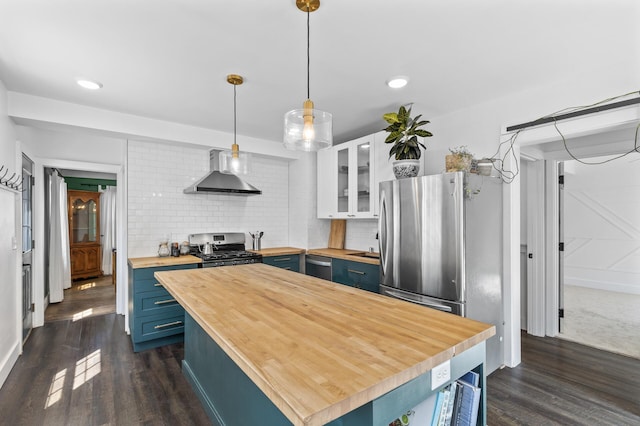 7537 Wentworth Ave, Richfield, MN 55423 - kitchen featuring butcher block counters, wall chimney range hood, stainless steel appliances, blue cabinets, and dark wood finished floors