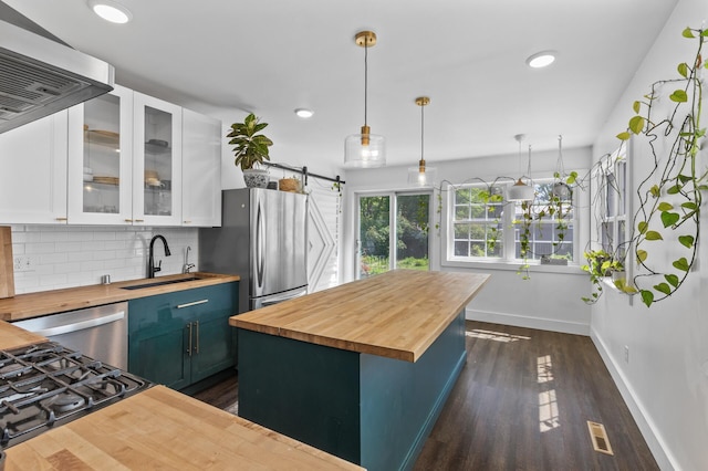 7537 Wentworth Ave, Richfield, MN 55423 - kitchen featuring wood counters, a sink, white cabinets, baseboards, and tasteful backsplash