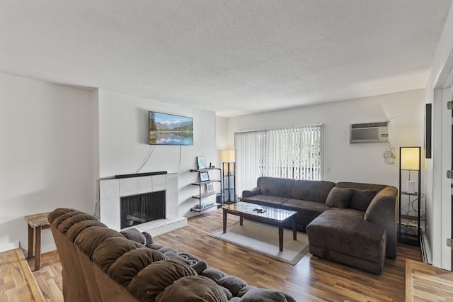 4207 Lakeside Ave N Unit 328, Brooklyn Center, MN 55429 - living room with a wall unit AC, a fireplace, a textured ceiling, and wood finished floors