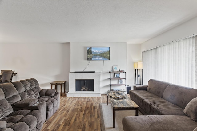 4207 Lakeside Ave N Unit 328, Brooklyn Center, MN 55429 - living area with wood finished floors, a tile fireplace, and a textured ceiling