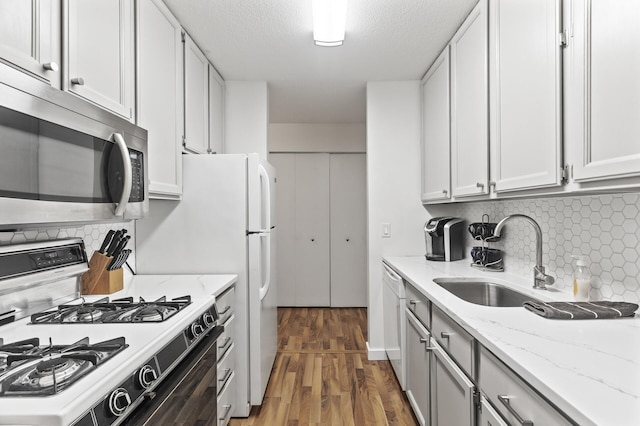 4207 Lakeside Ave N Unit 328, Brooklyn Center, MN 55429 - kitchen with gas range, stainless steel microwave, wood finished floors, a sink, and backsplash