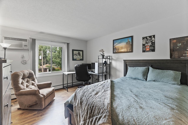 4207 Lakeside Ave N Unit 328, Brooklyn Center, MN 55429 - bedroom featuring a wall unit AC, wood finished floors, a textured ceiling, and baseboard heating