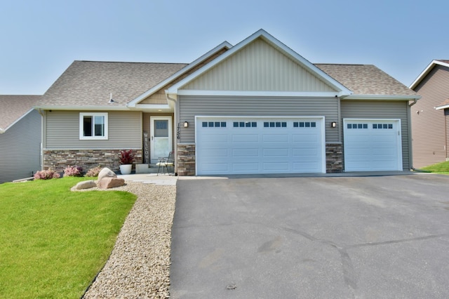1756 34th St NE, Sauk Rapids, MN 56379 - craftsman-style home with asphalt driveway, an attached garage, board and batten siding, stone siding, and a front lawn