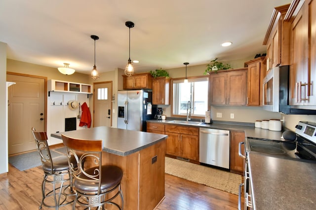 1756 34th St NE, Sauk Rapids, MN 56379 - kitchen with appliances with stainless steel finishes, a sink, brown cabinets, a kitchen island, and recessed lighting