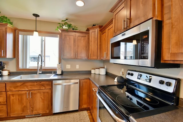 1756 34th St NE, Sauk Rapids, MN 56379 - kitchen with appliances with stainless steel finishes, a sink, dark countertops, brown cabinets, and recessed lighting