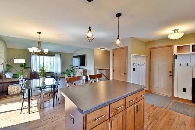 1756 34th St NE, Sauk Rapids, MN 56379 - kitchen featuring light wood-style floors, open floor plan, dark countertops, a kitchen island, and hanging light fixtures