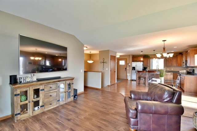1756 34th St NE, Sauk Rapids, MN 56379 - living area featuring a chandelier, wood finished floors, and baseboards