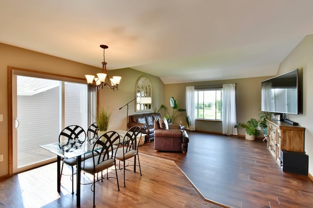 1756 34th St NE, Sauk Rapids, MN 56379 - dining space with lofted ceiling, a chandelier, wood finished floors, and baseboards
