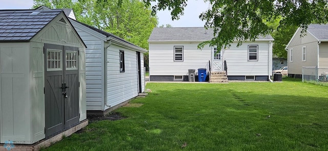 911 16th St N, Moorhead, MN 56560 - back of house featuring entry steps, a yard, and an outbuilding