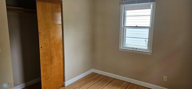 911 16th St N, Moorhead, MN 56560 - unfurnished bedroom with baseboards, multiple windows, light wood-type flooring, and a closet