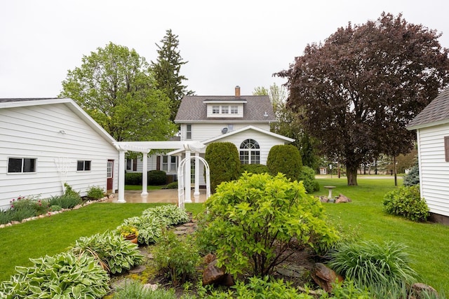 402 Main St, Racine, MN 55967 - view of front of home featuring a front lawn, a patio area, a pergola, a chimney, and roof with shingles