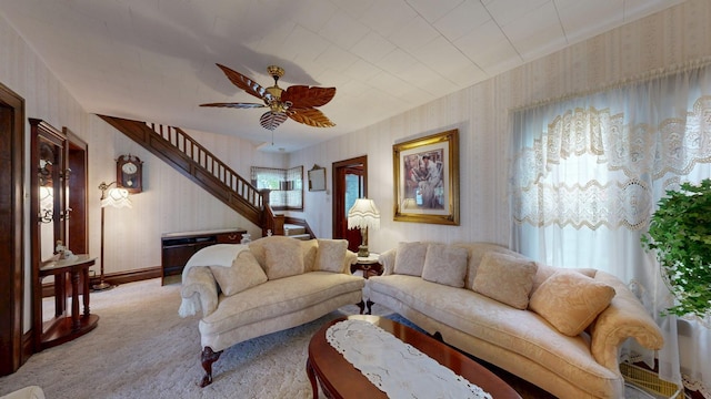 402 Main St, Racine, MN 55967 - living room featuring wallpapered walls, stairway, light carpet, and ceiling fan