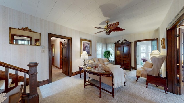 402 Main St, Racine, MN 55967 - living room with light carpet, wallpapered walls, ceiling fan, baseboards, and stairs