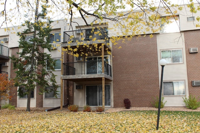 2800 Hillsboro Ave N Unit 316, New Hope, MN 55427 - back of house with a balcony, brick siding, and a lawn