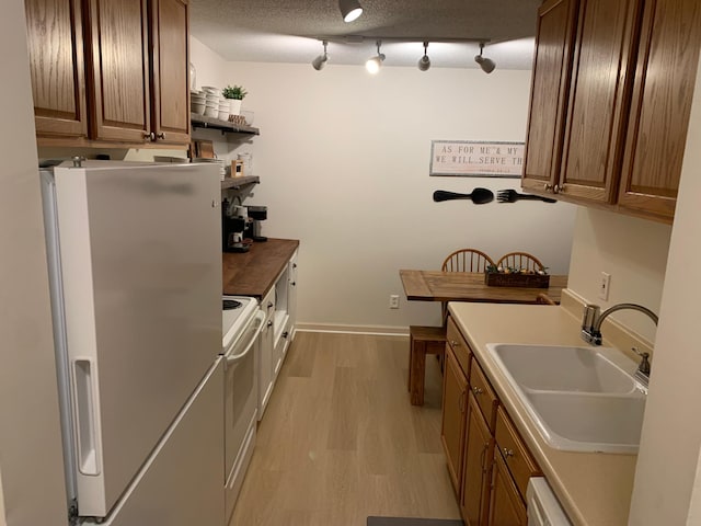 2800 Hillsboro Ave N Unit 316, New Hope, MN 55427 - kitchen with white appliances, a sink, light wood-style flooring, and brown cabinetry