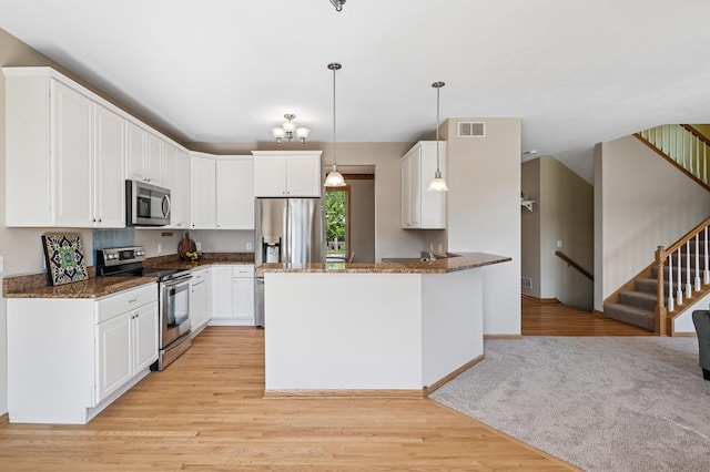 1498 Fox Meadow Dr, Delano, MN 55328 - kitchen with appliances with stainless steel finishes, light wood-style flooring, dark stone countertops, and a peninsula