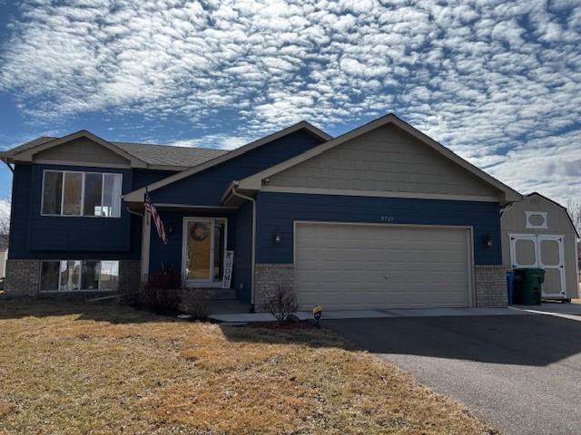9709 42nd St NE, Saint Michael, MN 55376 - tri-level home with brick siding, an attached garage, and asphalt driveway