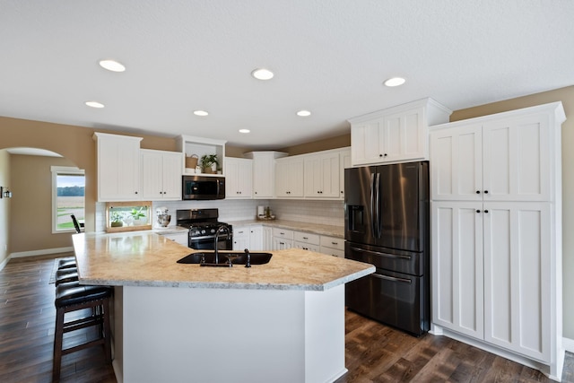 6339 140th Ave SE, Clear Lake, MN 55319 - kitchen featuring stainless steel appliances, decorative backsplash, dark wood-type flooring, white cabinets, and arched walkways