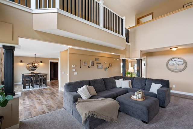 6339 140th Ave SE, Clear Lake, MN 55319 - living room featuring a high ceiling, a chandelier, decorative columns, and wood finished floors